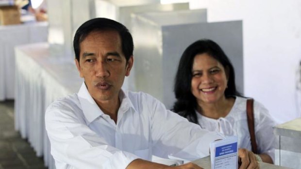 Leading presidential polls: Joko Widodo and his wife, Iriana, cast their ballot papers.