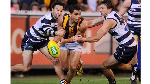 Geelong's Jimmy Bartel and Corey Enright give Hawthorn's Cyril Rioli no respite at the MCG.