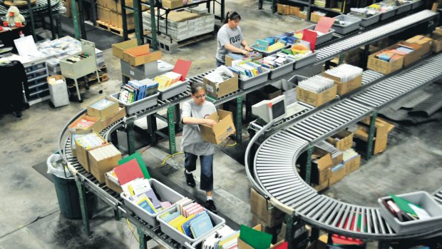 Workers prepare books for shipment in a US-based Amazon warehouse 