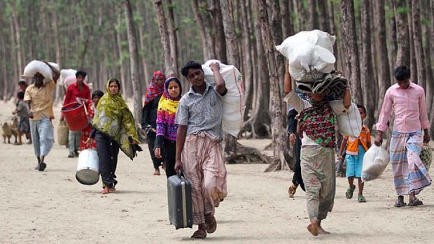 On the move: Evacuees make their way to shelters on Bangladesh's south-east coast before cyclone Mahasen hits.