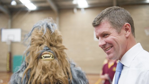  NSW Premier Mike Baird, at the Queanbeyan basketball centre, The Den, with the basketball association's mascot, a hairy yowie.
