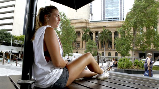 English backpacker Holly Marsh, 20, from Hertfordshire, relaxes in some shade in King George Square as temperatures hit 35 degrees on Saturday, Jan. 19.