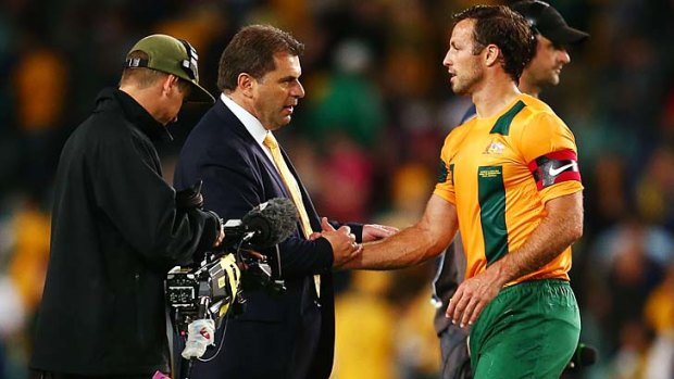 Socceroos coach Ange Postecoglou congratulates Lucas Neill after Australia won the international friendly match between the Socceroos and Costa Rica.