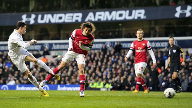 Tottenham Hotspur's Welsh defender Gareth Bale (left) takes a shot past Arsenal's Czech midfielder Tomas Rosicky (right) during the English Premier League match at White Hart Lane.