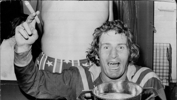 Graeme Langlands, with a cigar in his hand and the Ashes Cup full of champagne in the other, relaxes in the dressing room after leading Australia to their 22-18 win in the third Rugby League Test at the SCG on July 20, 1974.