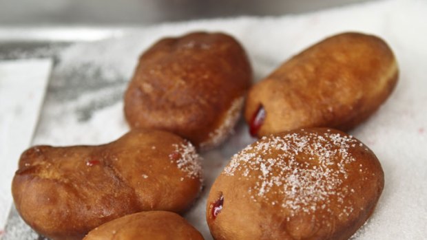 Jam donuts from Olympic Donuts await a final dusting of sugar.