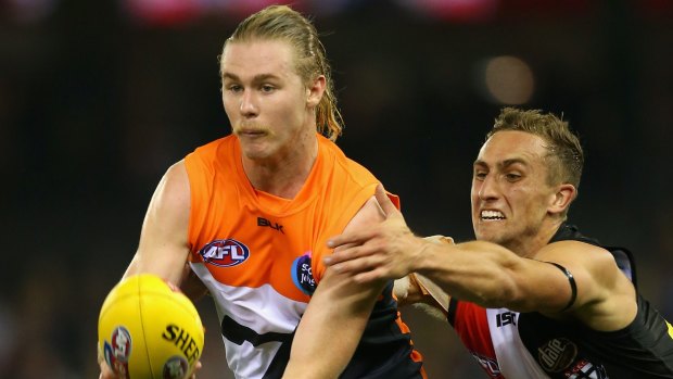 GWS' Cam McCarthy handballs under pressure from Luke Dunstan.