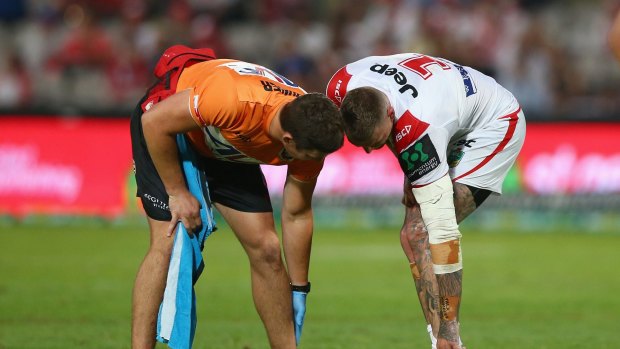 Fears: Josh Dugan gets some attention from the St George Illawarra trainer before leaving the field during the Dragons' loss to Melbourne.