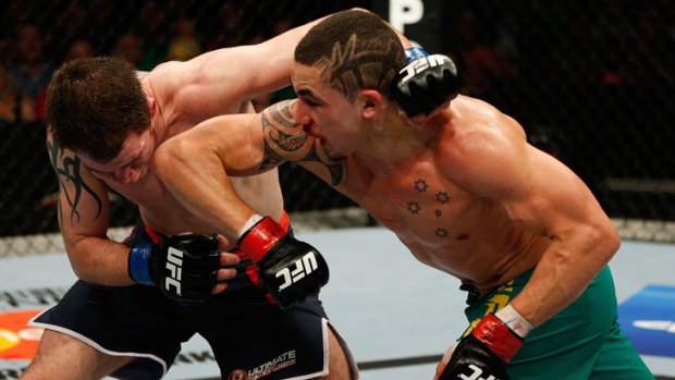Australian UFC fighter Robert Whittaker (right) lands an elbow to the jaw of Team UK fighter Brad Scott during his TUF: The Smashes welterweight final victory on the Gold Coast in December.