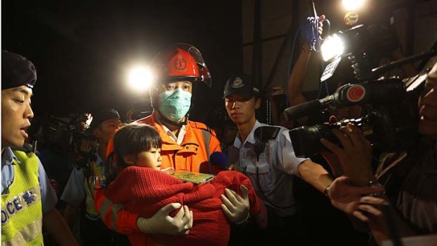 A young survivor is carried by a rescuer, and taken onto shore after a collision involving two vessels in Hong Kong.