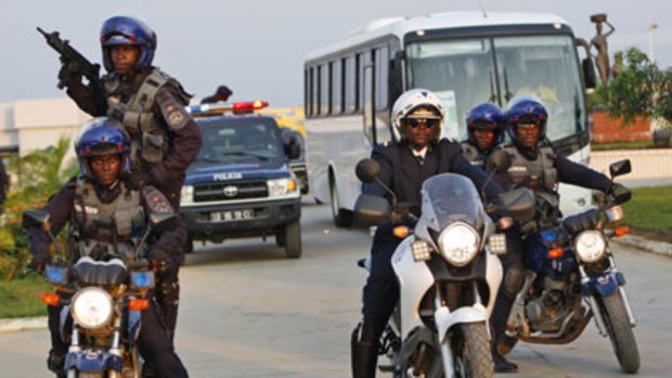 High alert...police escort the Ivory Coast team from their compound in Cabinda.