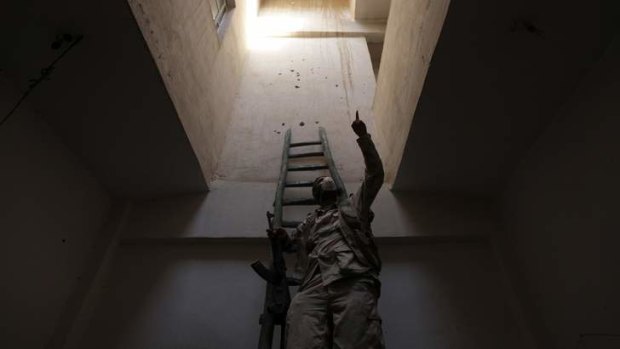 Hope for a strike: A Free Syrian Army fighter, carrying his weapon, climbs a ladder inside a building in Deir al-Zor.