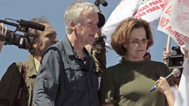 Director James Cameron  and actress Sigourney Weaver march  in Brasilia during a protest  against a proposed dam in the Amazon.