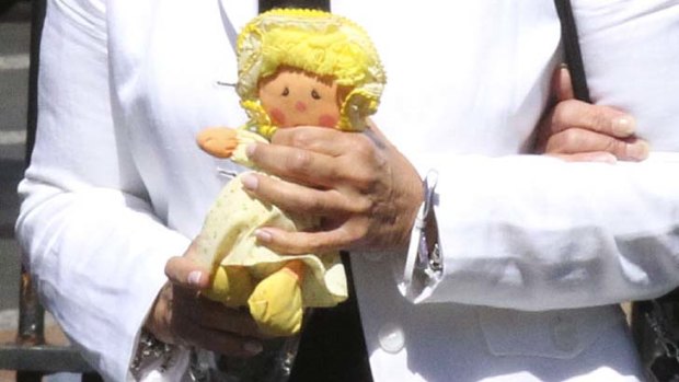 Lisa Harnum's mother, Joan Harnum, carries a doll, believed to have belonged to her daughter, at the NSW Supreme Court as the judge hands down her decision in the murder trial of Simon Gittany.