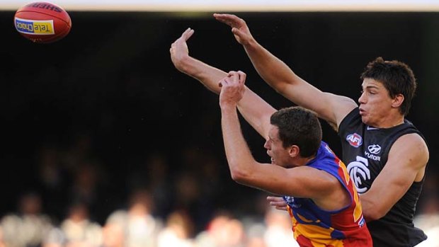 Lion Matthew Leuenberger vies for the ball with Carlton's Matthew Kreuzer.