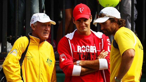 Roger Federer (centre) has a chat with Australian coach Tony Roche (left) and Pat Rafter at the Davis Cup tie yesterday.