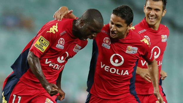 Bruce Djite of Adelaide celebrates his goal with teammates Isaias Sanchez and Marcelo Carrusca.