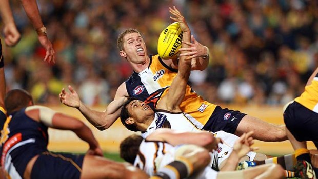 Up for grabs: West Coast's Adam Selwood and Hawthorn's Cyril Rioli battle for the ball last night.