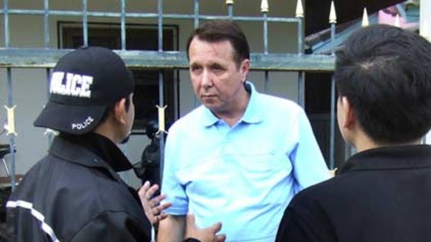 Russian pianist and conductor Mikhail Vasillievich Pletnev is questioned by a Thai police officer in front of his residence in Pattaya.