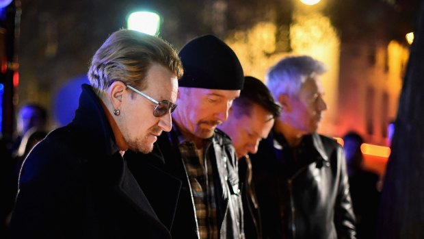 Bono and band members of U2 pay their respects and place flowers on the pavement near Bataclan Concert Hall.