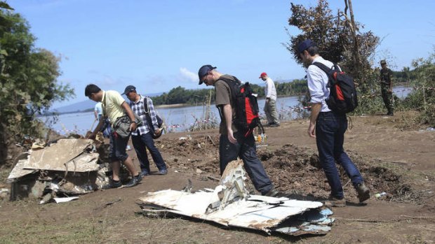 Picking up the pieces: French air crash investigators  walk among the wreckage of the Lao Airlines plane recovered from the Mekong River.