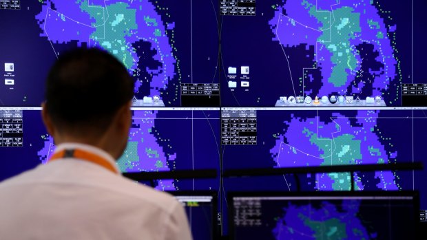 An Ihse employee looks at monitors displaying an air traffic control management system at the Singapore Airshow.