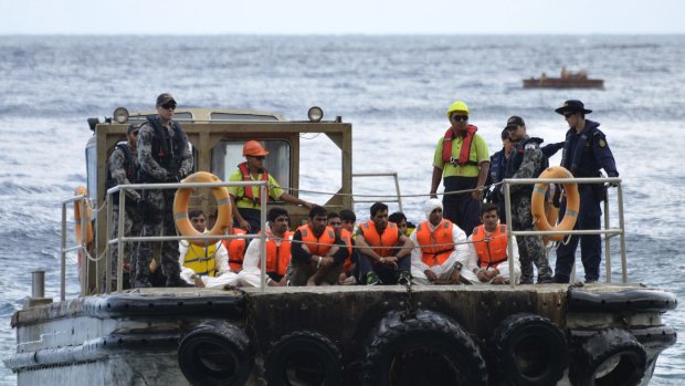 Australian customs officials and navy personnel escort asylum-seekers onto Christmas Island 