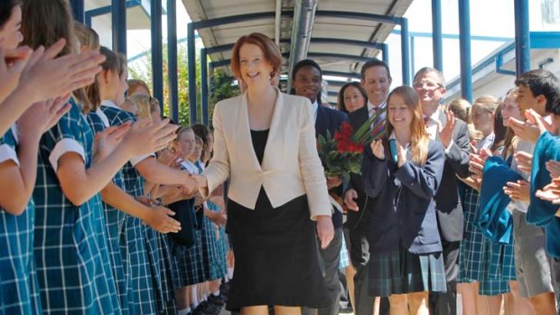 Students greet a smiling Julia Gillard during a visit to St Mary MacKillop College in Canberra.