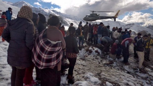 Waiting for help: A Nepalese army helicopter rescues survivors.