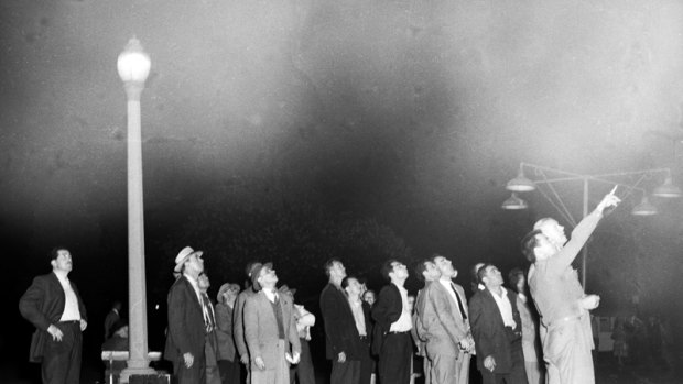 A crowd in Hyde Park, Sydney, tracks the Russian satellite, Sputnik I, as it travels across the night sky, 9 October 1957. 