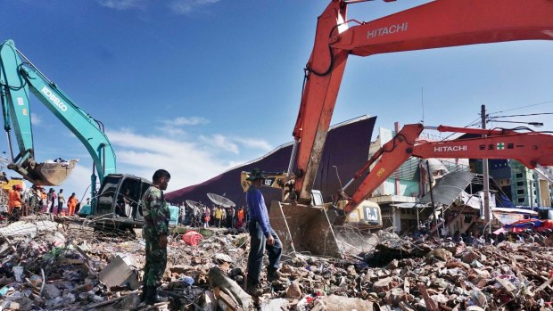 ACEH, INDONESIA - DECEMBER 8: People walk on the debris of a collapsed building as the search and rescue works continue after a strong earthquake shook the north of Indonesia's Sumatra island Wednesday morning, killing at least 92 people and causing dozens of buildings to collapse, at Merdu village, Pidie Jaya, Indonesia, on December 8, 2016 Photo Jefri Tarigan.