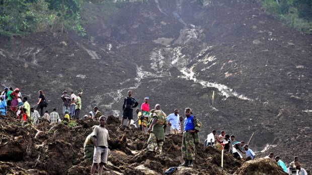 "This may end up a mass grave" ... soldiers and relatives try to retrieve the bodies of villagers buried under a wall of earth in Uganda's east.