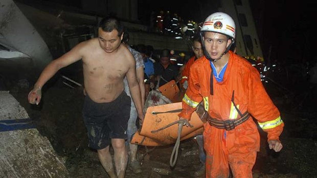 An injured passenger is carried from the wreckage.