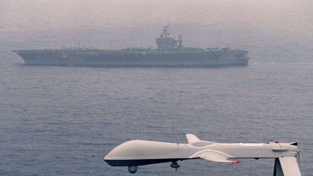 The Predator unmanned aerial vehicle flies above the USS Carl Vinson.