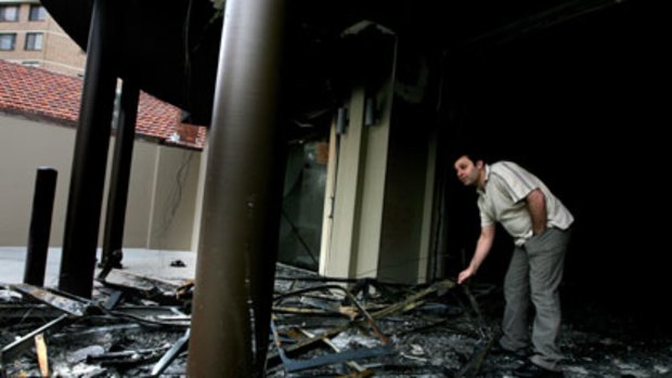 Targeted...Charles Obeid stands amid the ruins of his restaurant which was torched on Tuesday night.