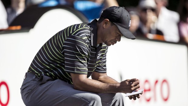 Not quite ready: Tiger Woods peruses his scorecard after the first round of the Hero World Challenge.