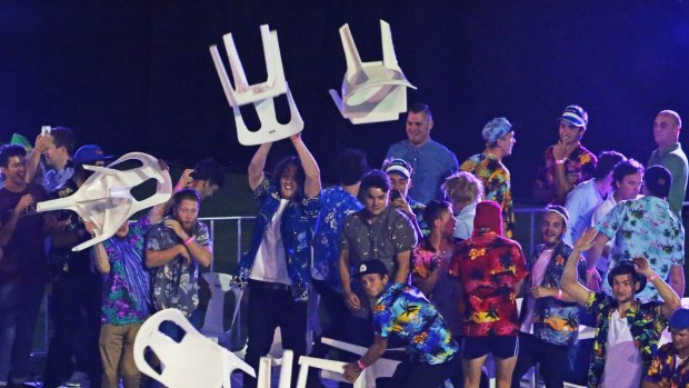 Spectators throw chairs and tables during the final between Simon Whitlock and Michael van Gerwen during the Invitational Darts Challenge at Etihad Stadium on January 10.