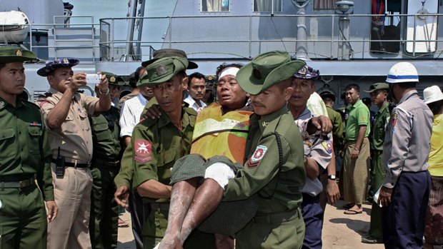 A survivor from a ferry accident in Myanmar that claimed at least 33 lives is carried by two Myanmar army soldiers from a navy vessel at Kyaukphyu jetty in western Myanmar Rakhine state. 