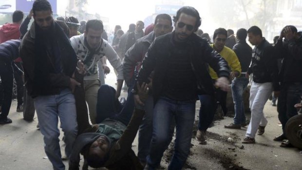 Violence: Demonstrators carry an injured Muslim Brotherhood supporter who was shot during clashes in Cairo.