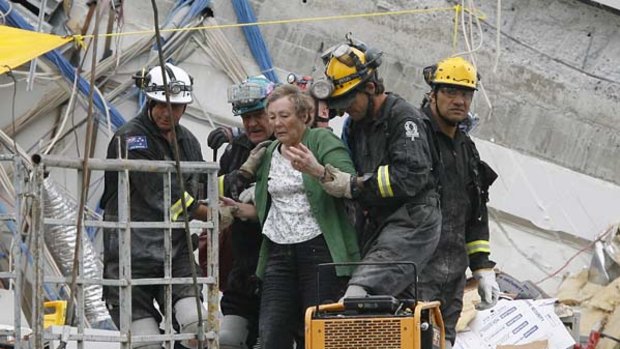 Rescued  ... a woman is freed from the ruins of the Pyne Gould Guinness building after being trapped for more than 20 hours. Search teams went in with equipment to hear the cries of survivors. One team member said the building had "pancaked."