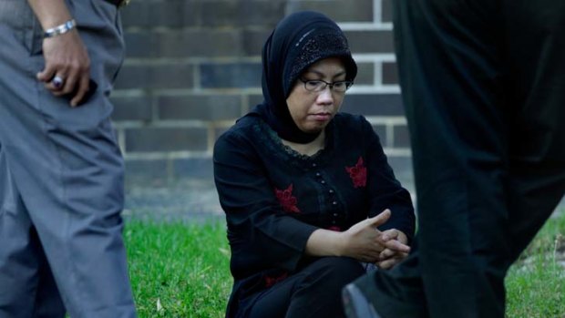 Stabbing ... a Malaysian woman sits near the crime scene in Leichhardt where Mohd Shah Saemin was fatally stabbed.