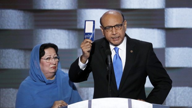 Khizr Khan, father of fallen US Army Captain Humayun Khan, holds up a copy of the US constitution at the Democratic National Convention as his wife Ghazala listens.