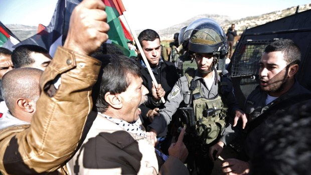 Palestinian minister Ziad Abu Ein (C) argues with Israeli border policemen during a protest near the West Bank city of Ramallah December 10