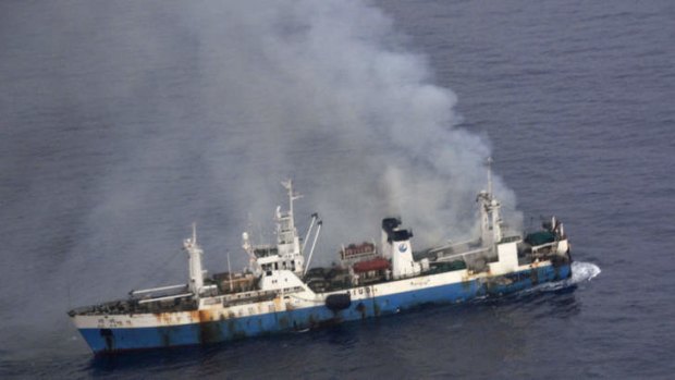 In this picture released by Chile's Air Force, smoke billows from a Chinese factory fishing ship Kai Xin just off the coast of Antarctica, Wednesday, April 17, 2013.