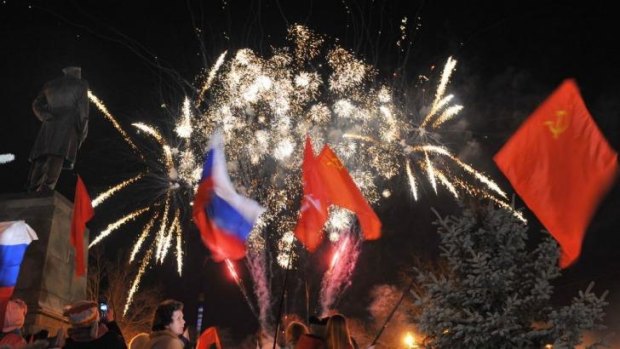Keeping the red flag: People wave Russian and Soviet flags as they watch fireworks in the Crimean city of Sevastopol.