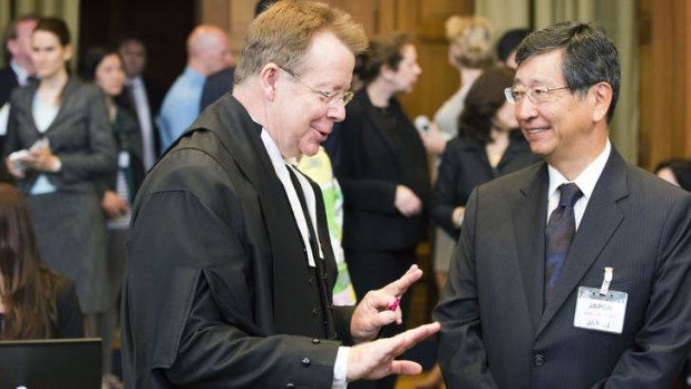 General Counsel of Australia Bill Campbell talks with Japanese Deputy Minister of Foreign Affairs Koji Tsuruoka at the International Court of Justice in The Hague.