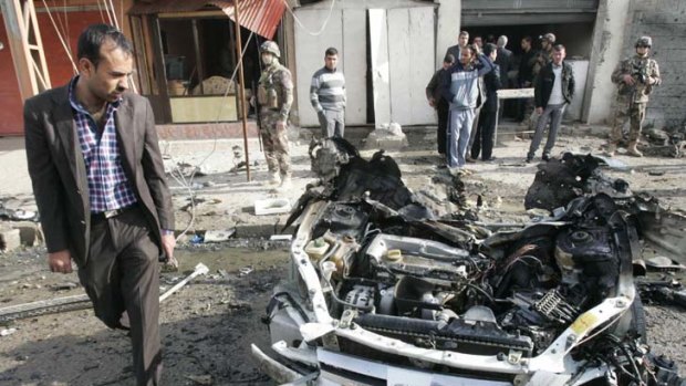 Scenes of violence &#8230; a man walks past the remains of a vehicle used in a bomb attack in Kirkuk.