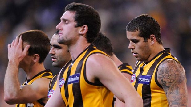 Feeling the pain: Hawthorn players after their narrow loss to Geelong at the MCG on Saturday night.