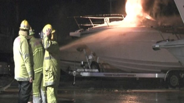 Firefighters attend the scene as a luxury boat burns in Fremantle this morning.