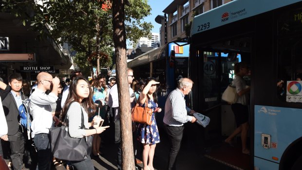 Commuters board a bus  at the Park and Elizabeth streets corner, which is said to have improved under the changes. 